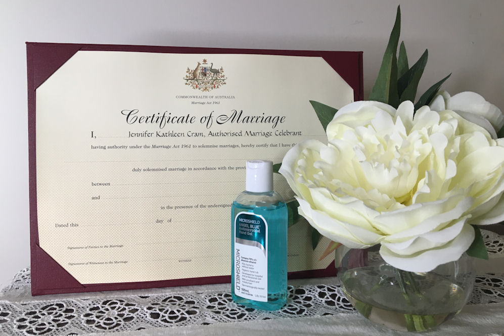 Marriage Certificate with White Peony in
                        glass vase and bottle of Hand Sanitiser