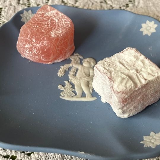 Two pieces of Turkish Delight on a blue
                      Wedgwood Jasper pin dish featuring a cherub
