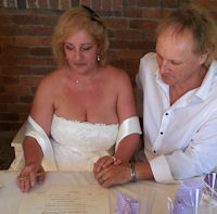 Laurence and Richard signing their marriage
                      certificate after their marriage by Jennifer Cram,
                      Brisbane Celebrant